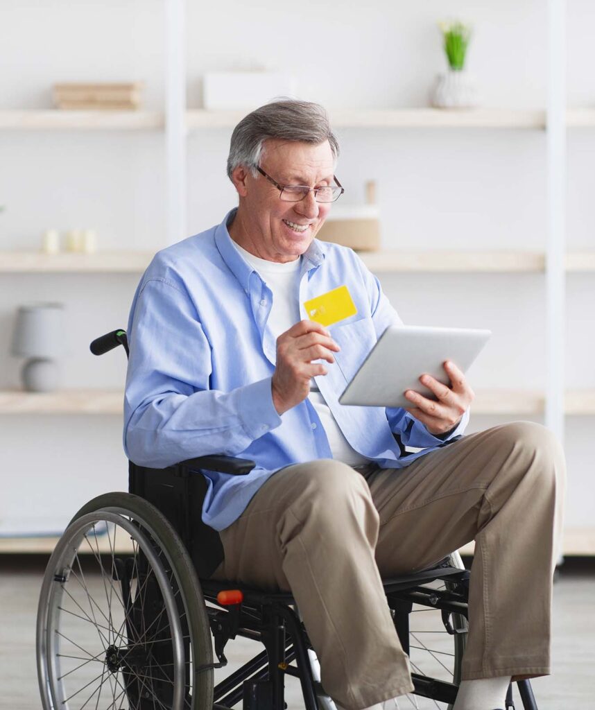 happy-senior-man-in-wheelchair-shopping-online-wit-AHKQ4NS.jpg